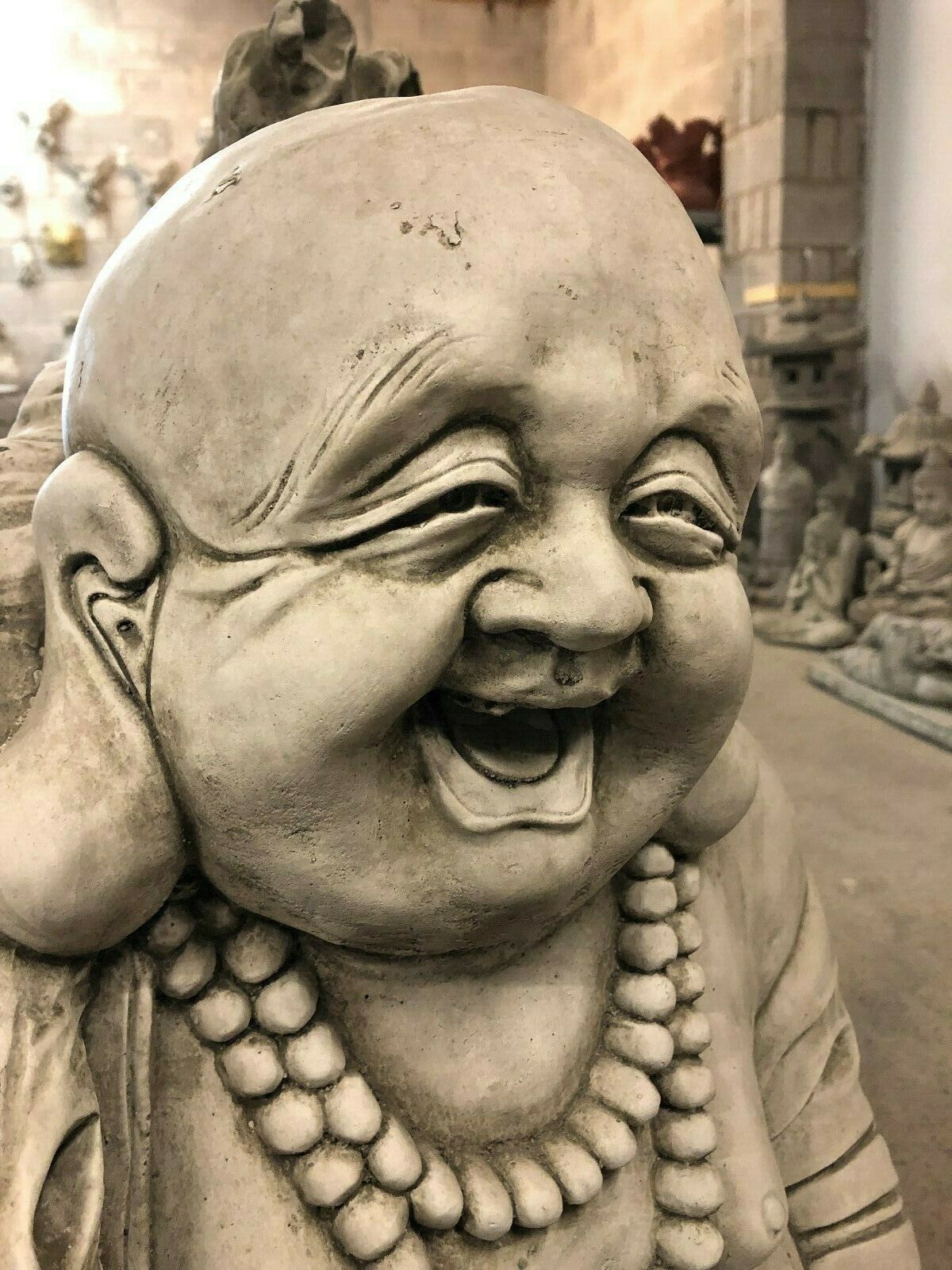 Facial close-up of Stone Laughing Buddha Statue, radiating joy and serenity, ideal for indoor zen or fortune-themed spaces.