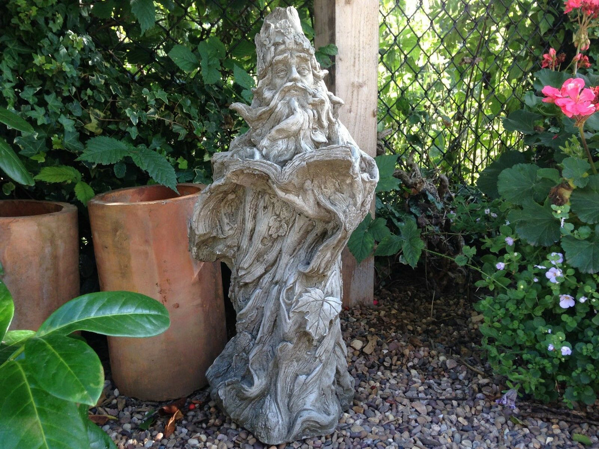 Wizard Garden Statue - Enchanting Decor placed among greenery and terracotta pots, ideal for magical outdoor garden settings.