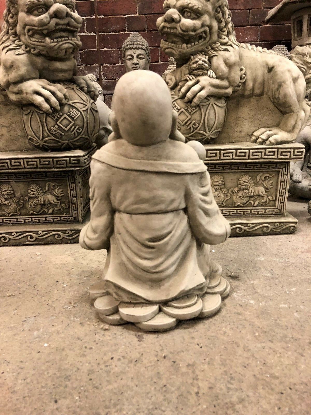 Back view of the Wealth Buddha Garden Statue on coin base, made from limestone with antique finish for outdoor décor.