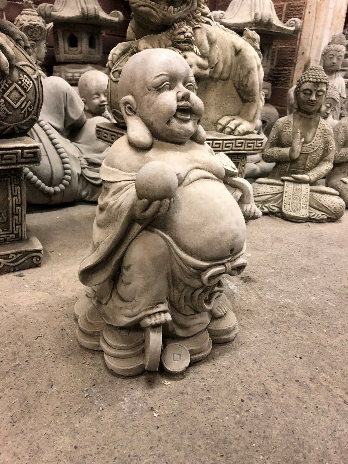 Side profile of stone Buddha statue with prosperity symbols, ideal for enhancing garden energy and wealth attraction.