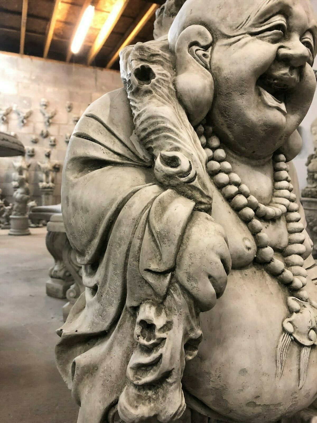 Side detail of Laughing Buddha Statue’s robe and staff, emphasizing the intricate stone carving and symbolic fortune design.