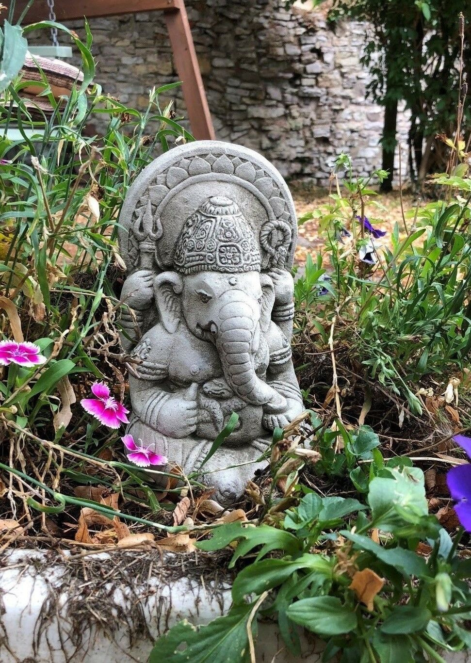 Ganesh Garden Ornament - Small Stone surrounded by blooming flowers. A spiritual and decorative touch for garden beds.