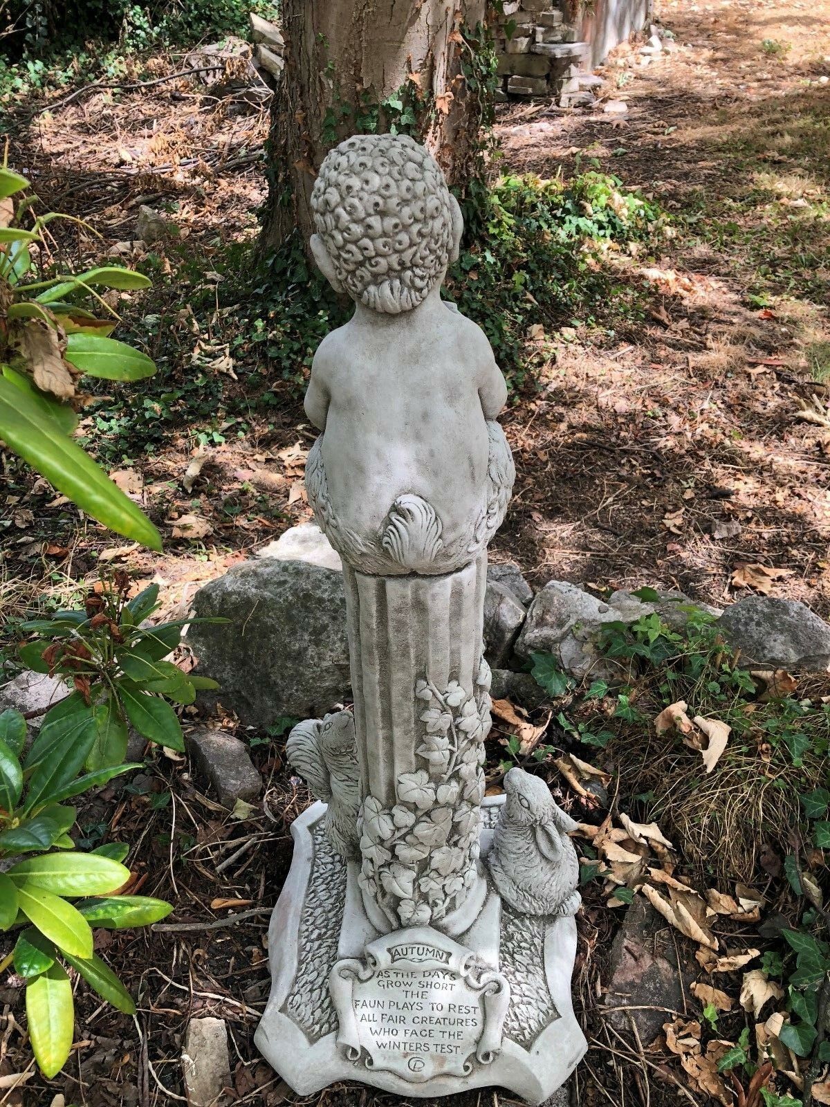 Autumn-themed stone garden statue from the Four Seasons collection, featuring a faun and engraved seasonal poem on the base.