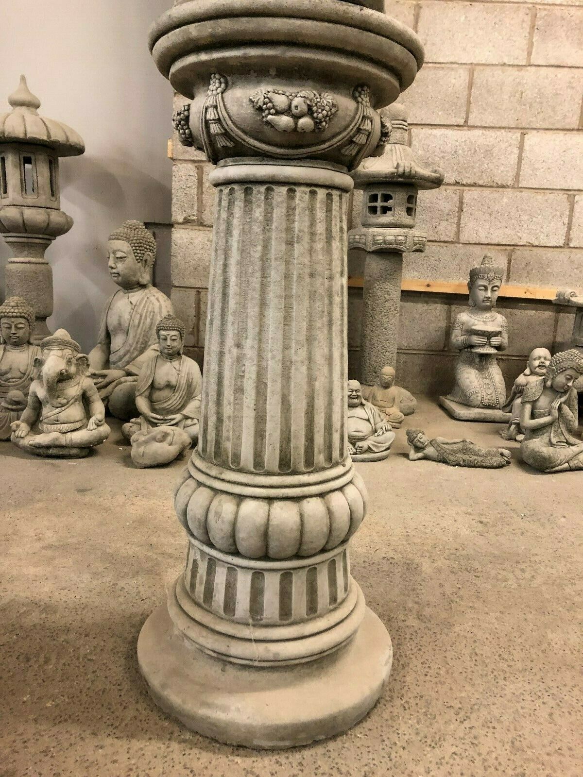 Lower portion of the Stone Seated Buddha Statue pedestal, featuring classical column design for garden ornamentation.