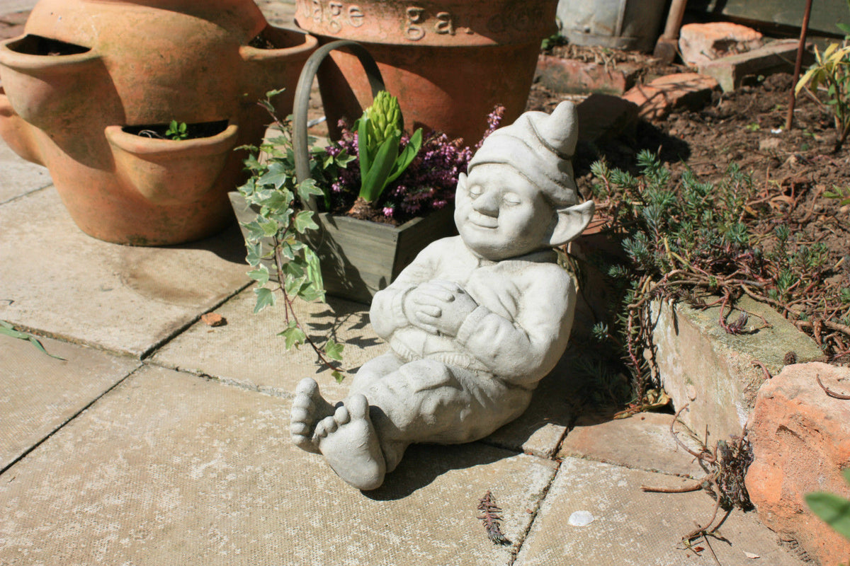 Garden Gnome Ornament - Relax outdoors | Durable & Antique Finish, lounging beside flower pots on patio, adds charm to garden landscaping.