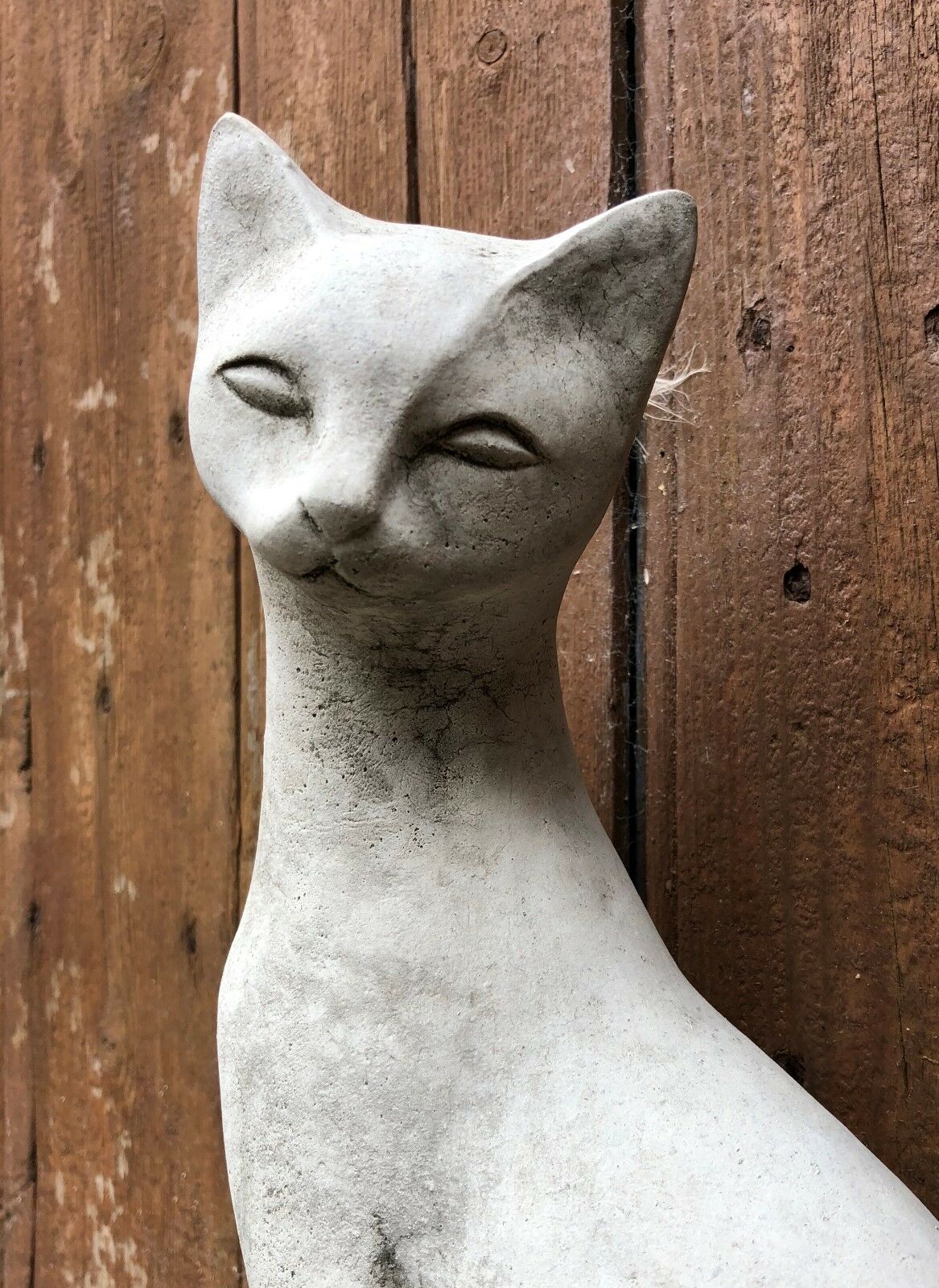 Close-up of a single stone Siamese cat statue showing detailed facial features and smooth texture, ideal for garden or patio decoration.