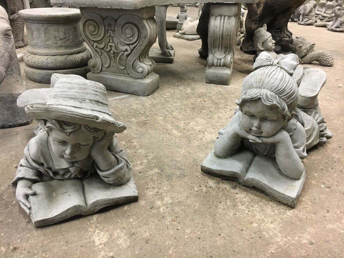 Stone Reading Boy & Girl Garden Statues with intricate detailing, perfect for outdoor decoration and patio ornamentation.