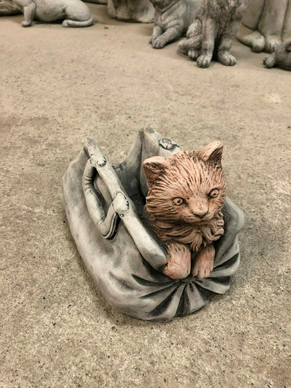 Unique Garden Ornament - Stone Cat In Bag Planter with intricate fur detailing and weathered limestone texture, ideal for outdoor flower displays.
