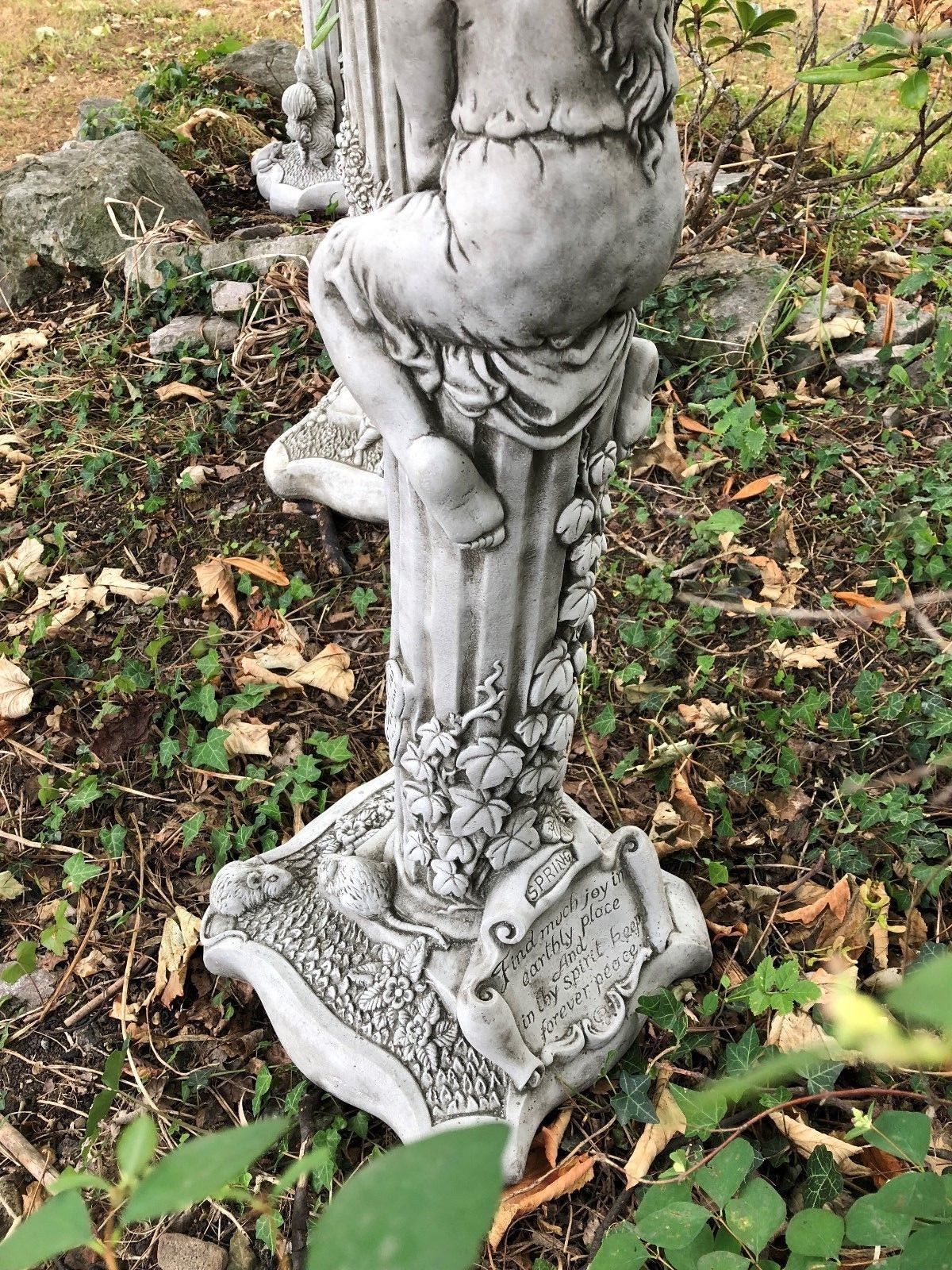 Close-up of Spring statue from Stunning Stone Garden Statues - Four Seasons Statues, showing detailed ivy carvings and poetic inscription.