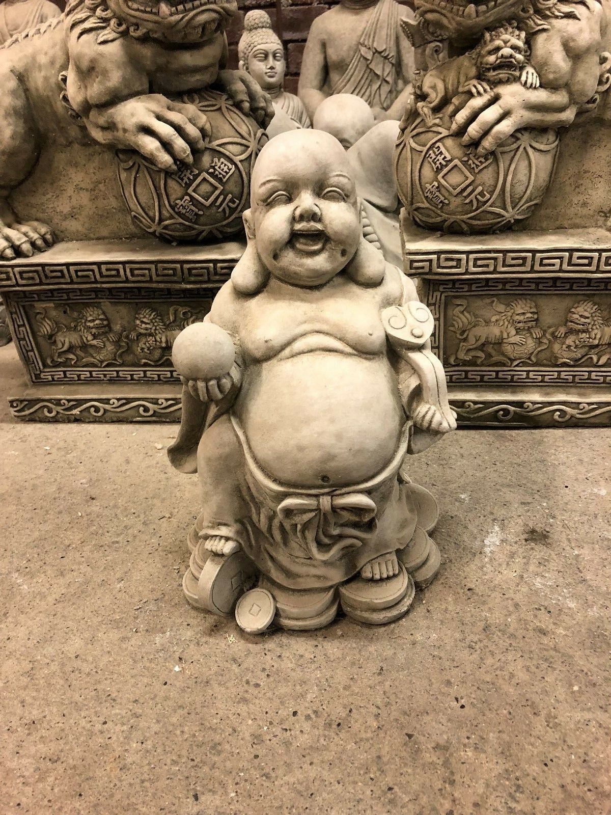 Front view of limestone Wealth Buddha statue with ball and scroll, symbolizing abundance and protection for home gardens.