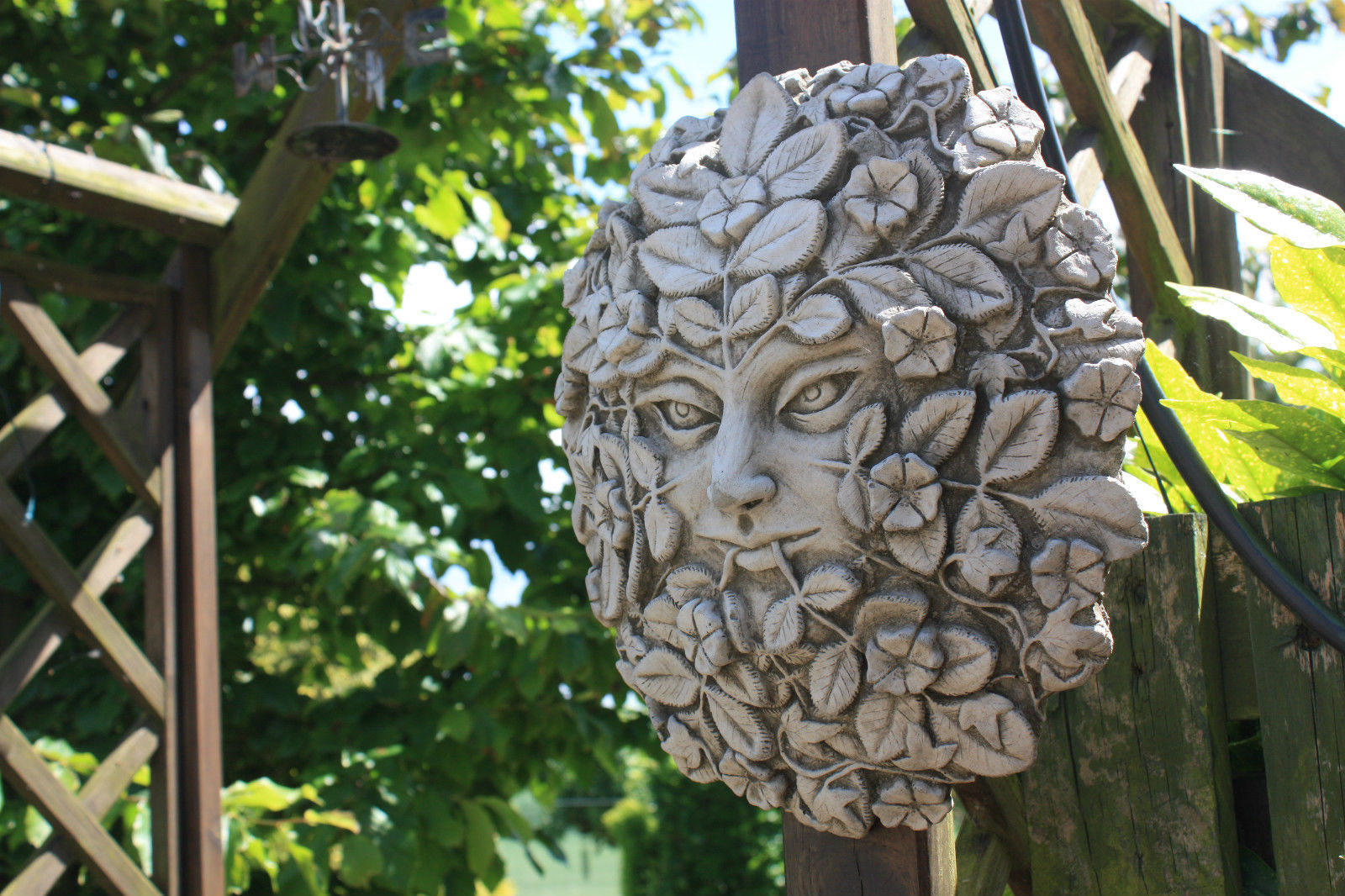 Greenwoman garden wall plaque with floral and leaf detail in antique grey limestone, perfect for enhancing garden trellis decor.