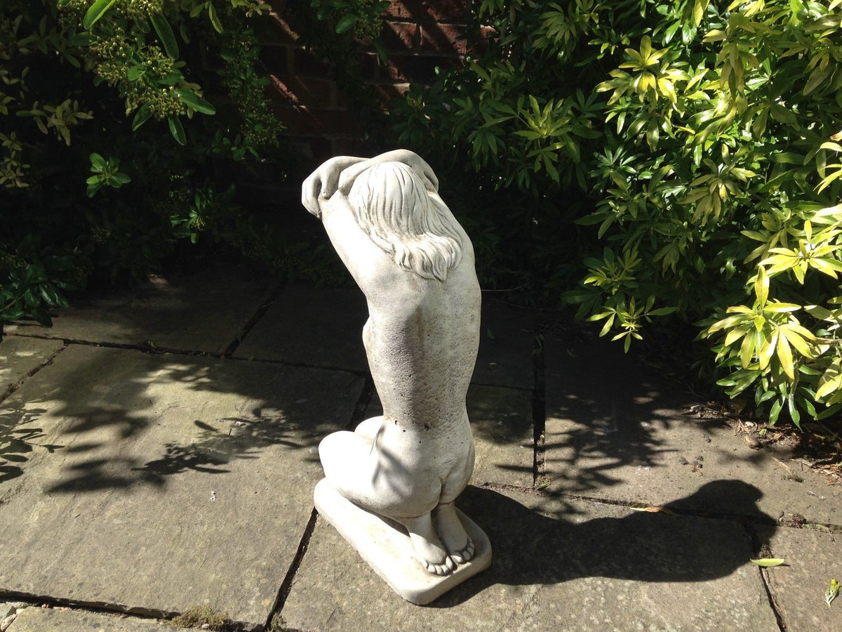 Back view of Kneeling Nude Lady Statue in stone, showing detailed hair and posture. Durable and artistic garden sculpture.