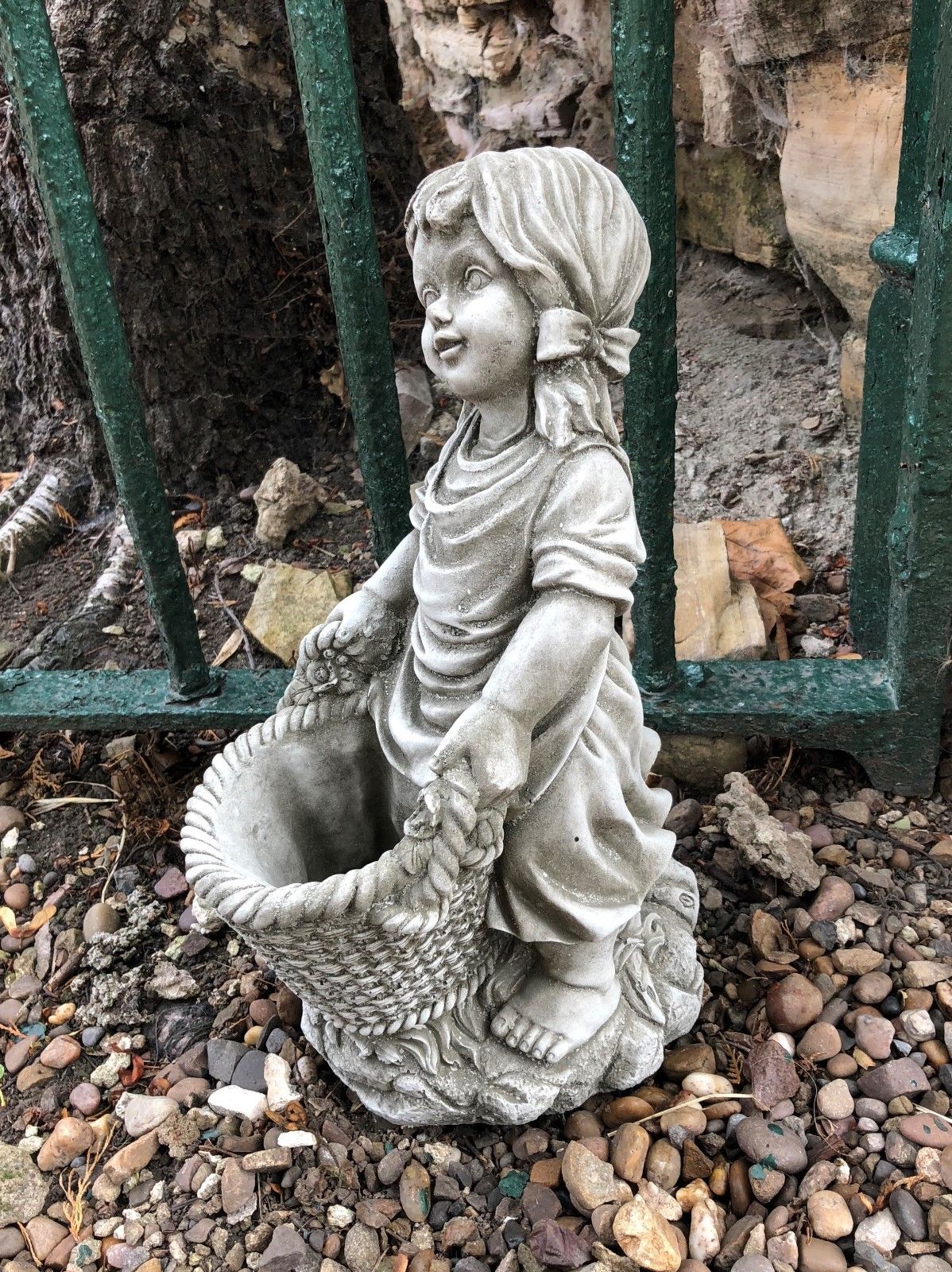 Basket girl garden ornament in antique stone finish, holding a woven-style planter, ideal for planting flowers in garden or patio.