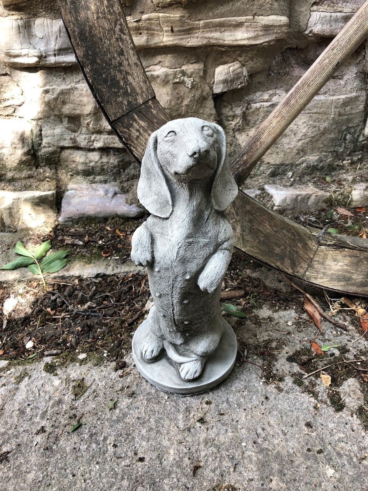 Detailed stone dachshund statue for garden ornamentation. Weather-resistant design perfect for UK outdoor spaces and home gardens.