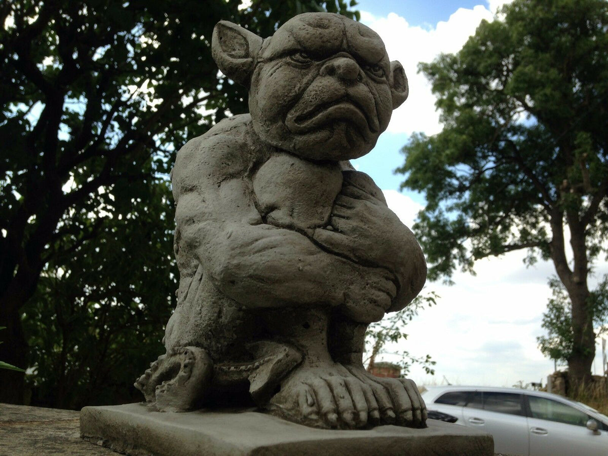 Detailed view of Grumpy Stone Gargoyle Statue with muscular build. Durable limestone sculpture for outdoor garden or patio use.