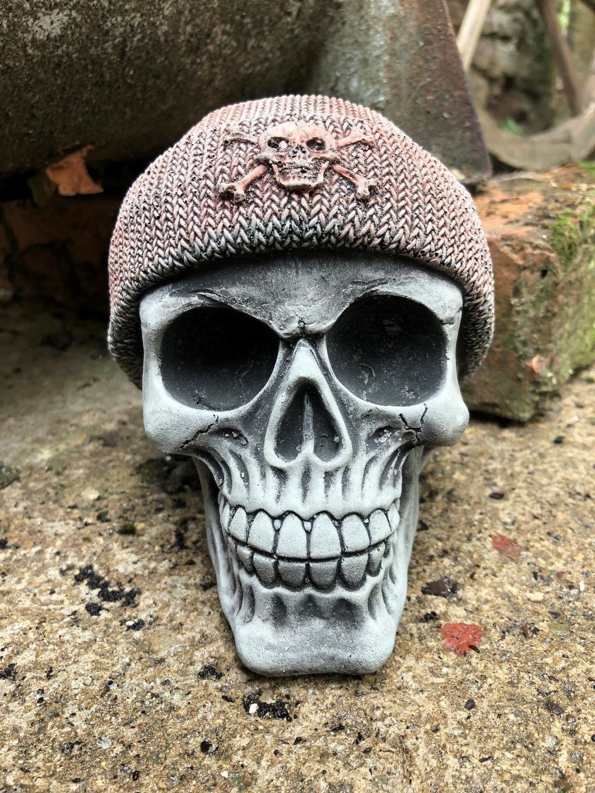 Stone Skull Beanie Ornament with detailed teeth and eye sockets, ideal for garden decor. Features a textured knit-style beanie with skull emblem.