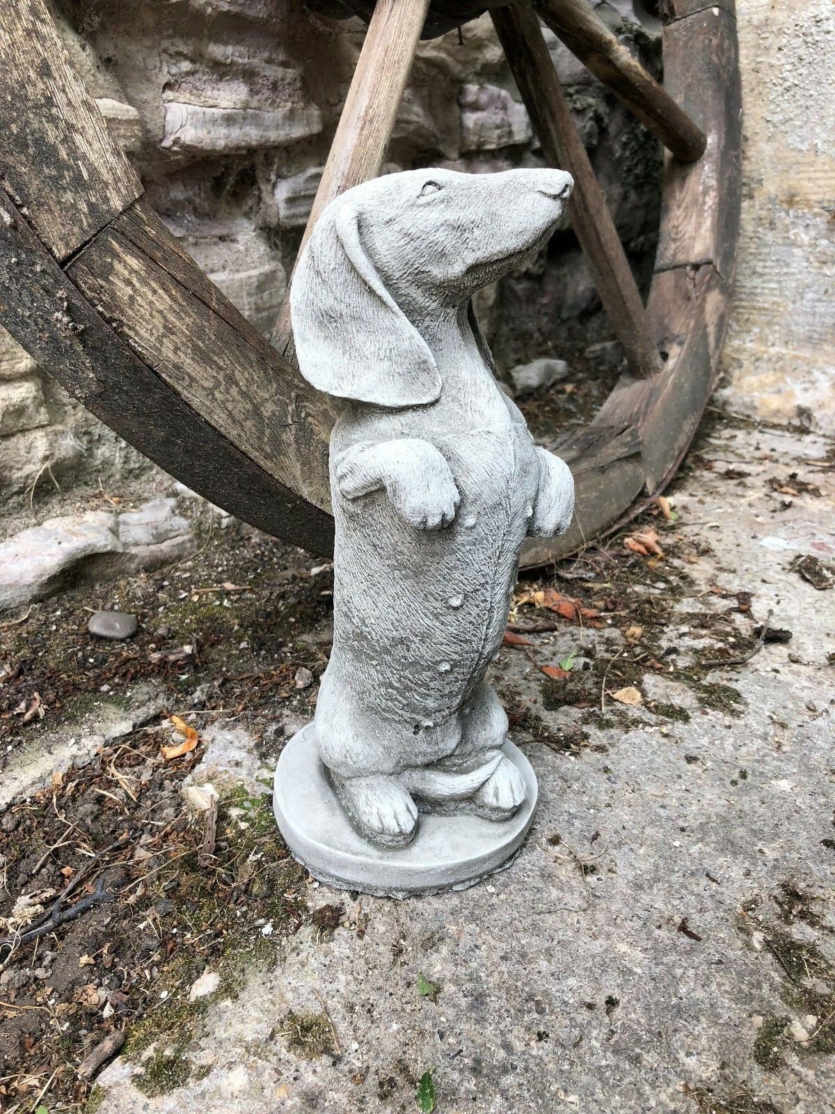 Side view of a stone dachshund garden statue with realistic texture. A charming outdoor ornament for dog lovers and garden decor.