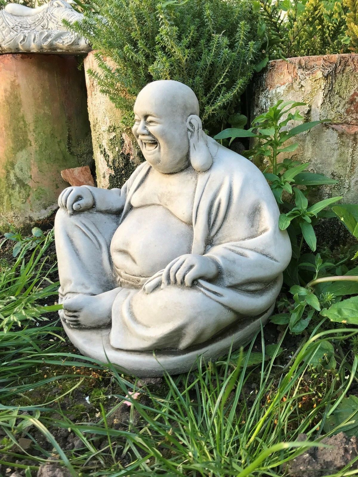 Side view of Stone Laughing Buddha Ornament seated in a meditative pose, crafted from limestone for garden or patio decor.