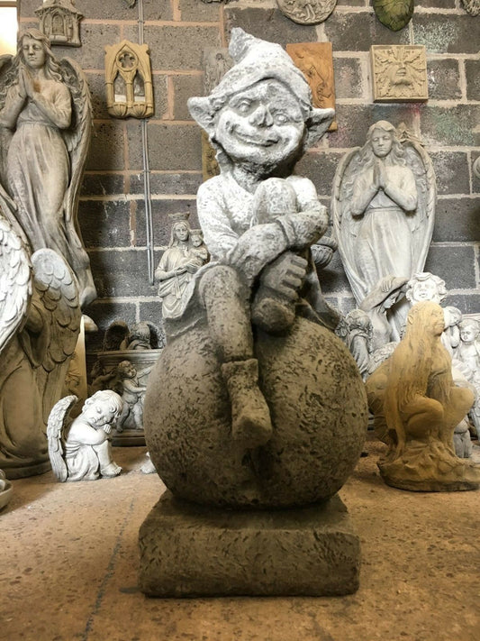 Stone Pixie on Ball Statue - Weatherproof Decor | Durable garden ornament featuring a smiling pixie sitting on a textured stone ball.
