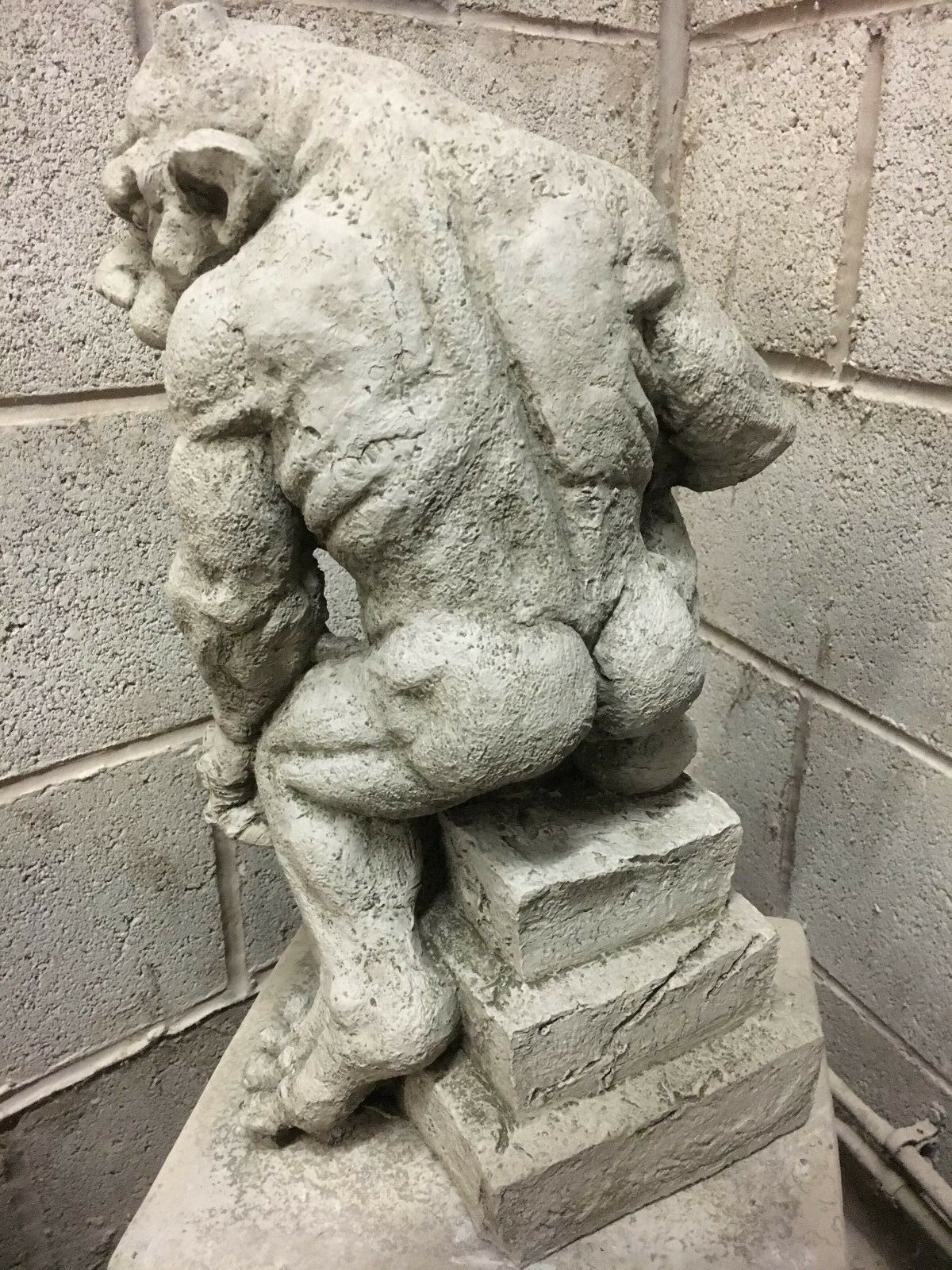 Top-down angle of menacing stone gargoyle statue highlighting detailed claws and muscular build, crafted for outdoor garden decor.