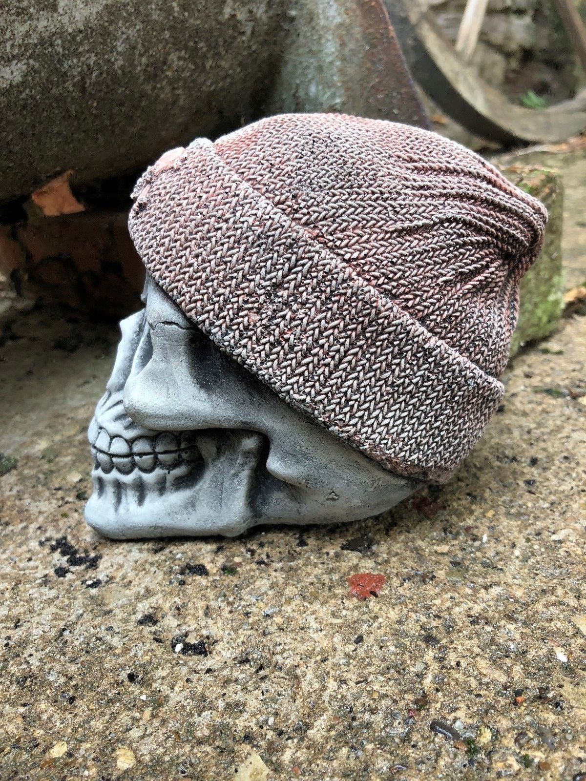 Left profile of Stone Skull Beanie Ornament showing the beanie's woven texture and skull motif, a bold addition to home or garden decor.