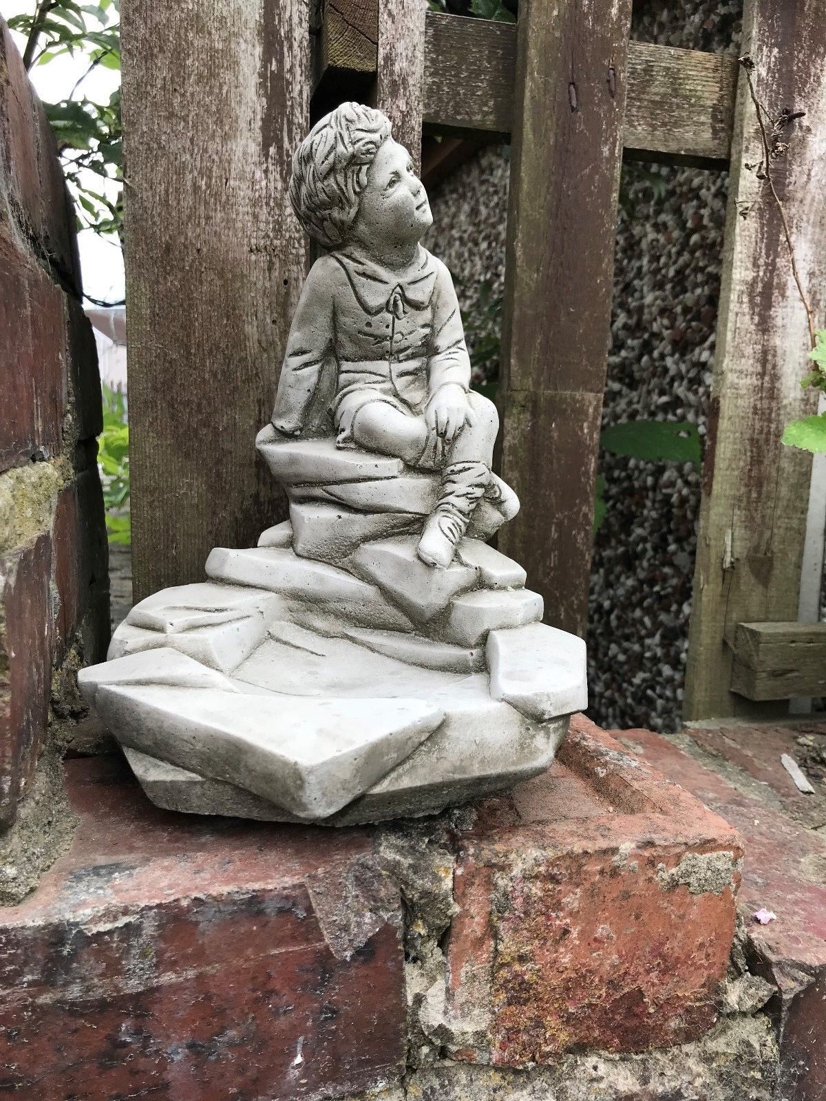Garden Bird Feeder - Stone Thinking Boy Sculpture features a seated child on a rock base, ideal as a handmade patio decor ornament in antique grey finish.