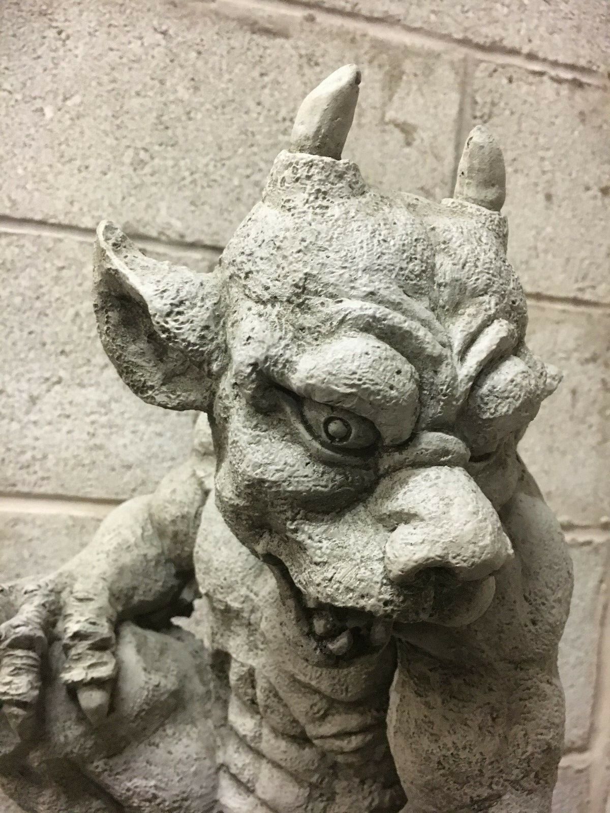 Group of stone gargoyle statues with one elevated as a centerpiece, showcasing gothic garden sculpture collection for outdoor spaces.