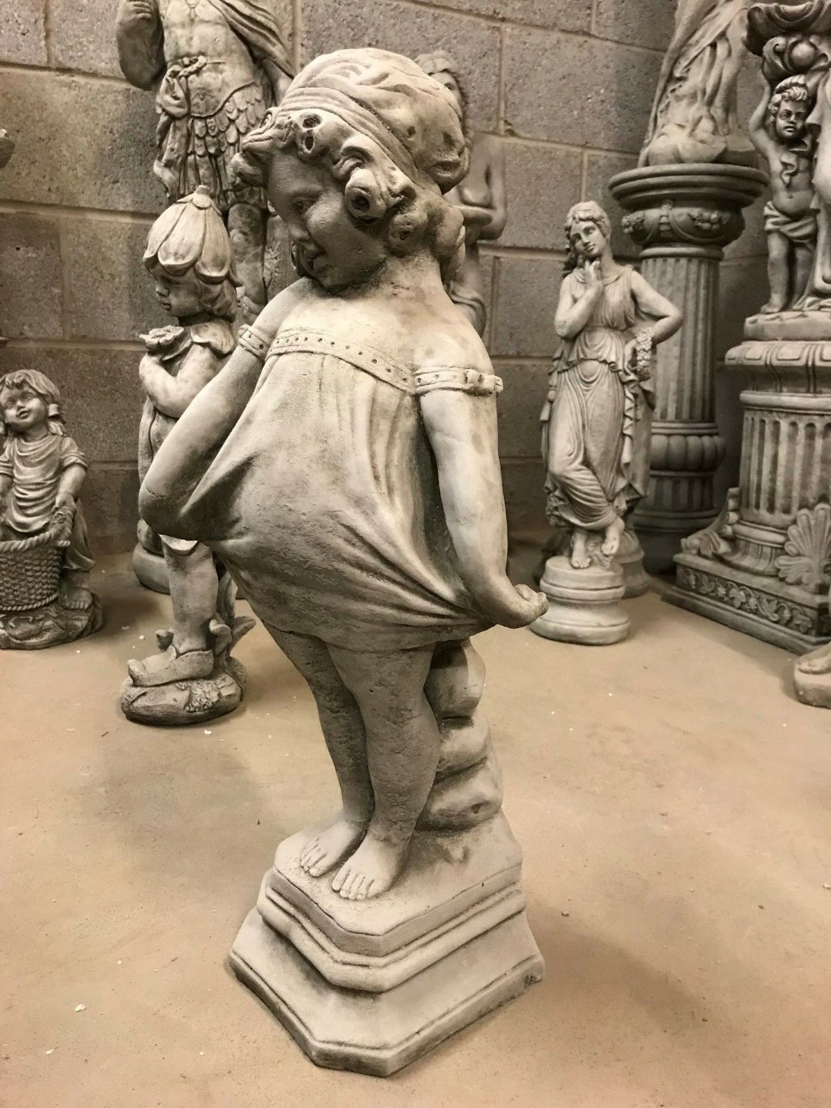 Detailed side view of Shy Girl Stone Garden Ornament, showcasing intricate curls and dress folds, crafted for outdoor decoration.
