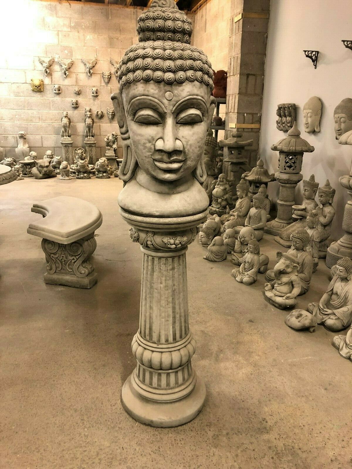 Full view of tall Buddha Head Garden Statue with fluted pedestal base. Durable stone sculpture perfect for garden or lawn ornamentation.