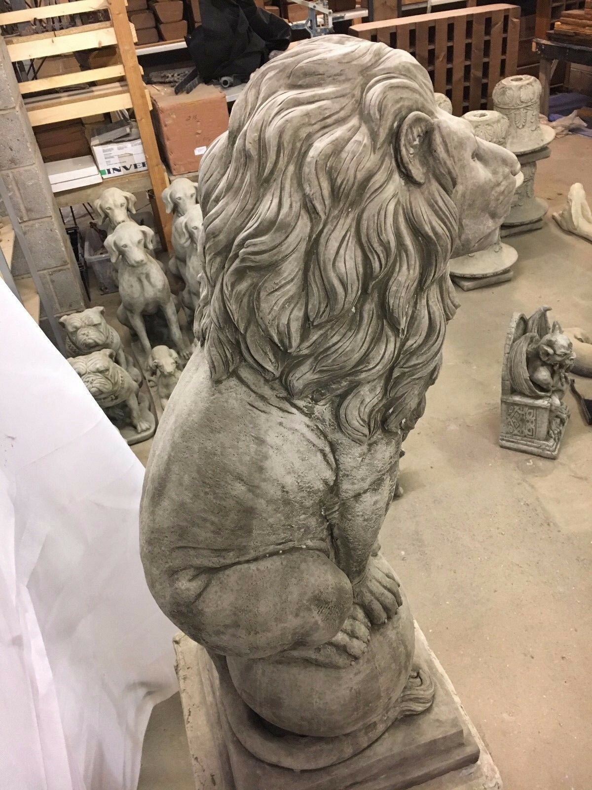 Close-up side view of a stone lion statue showing intricate mane detailing and solid limestone texture, suited for outdoor ornamentation.