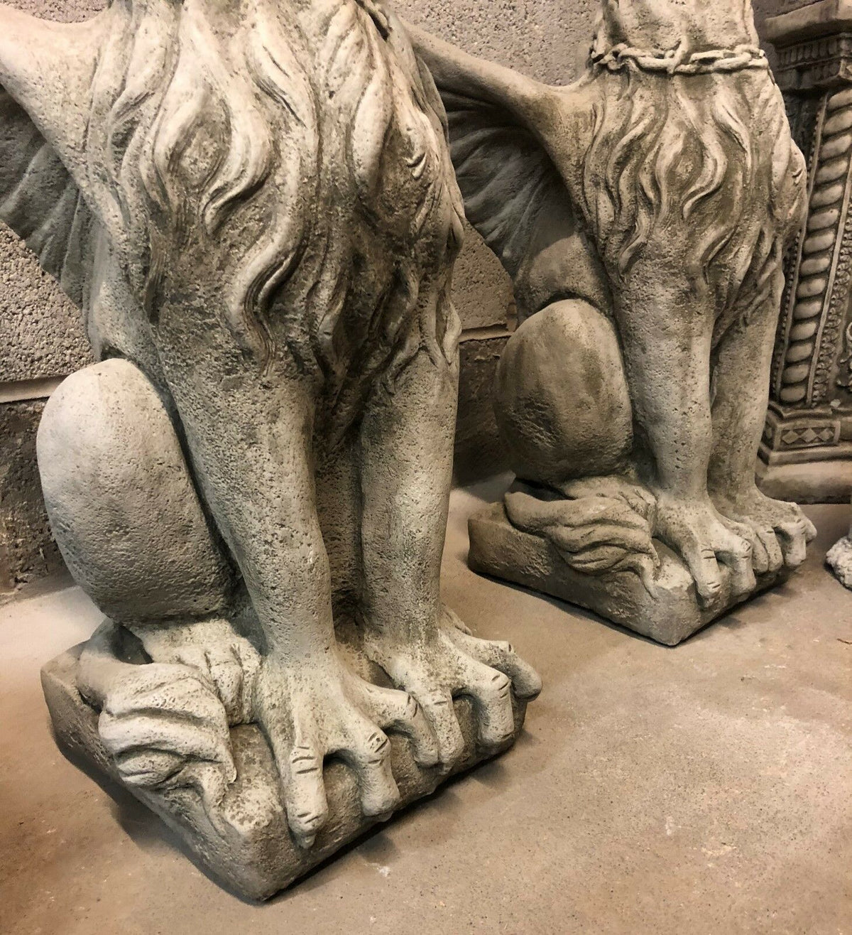 Close-up of the base and claws of limestone phoenix statues, showcasing intricate craftsmanship and solid stone design.