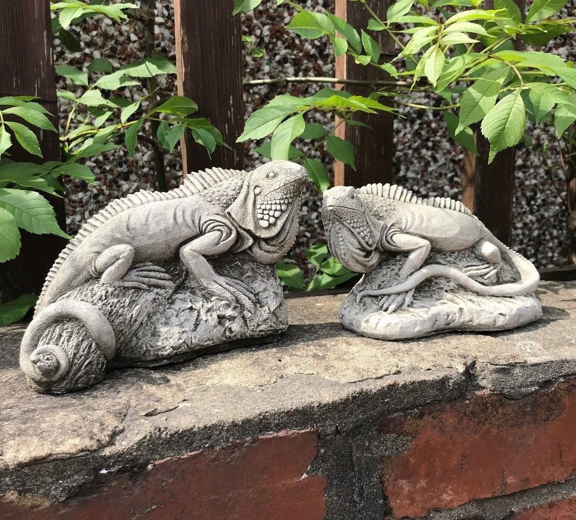 Two Iguana Stone Garden Ornaments displayed on a brick ledge, highlighting realistic texture and weather-resistant craftsmanship for garden settings.