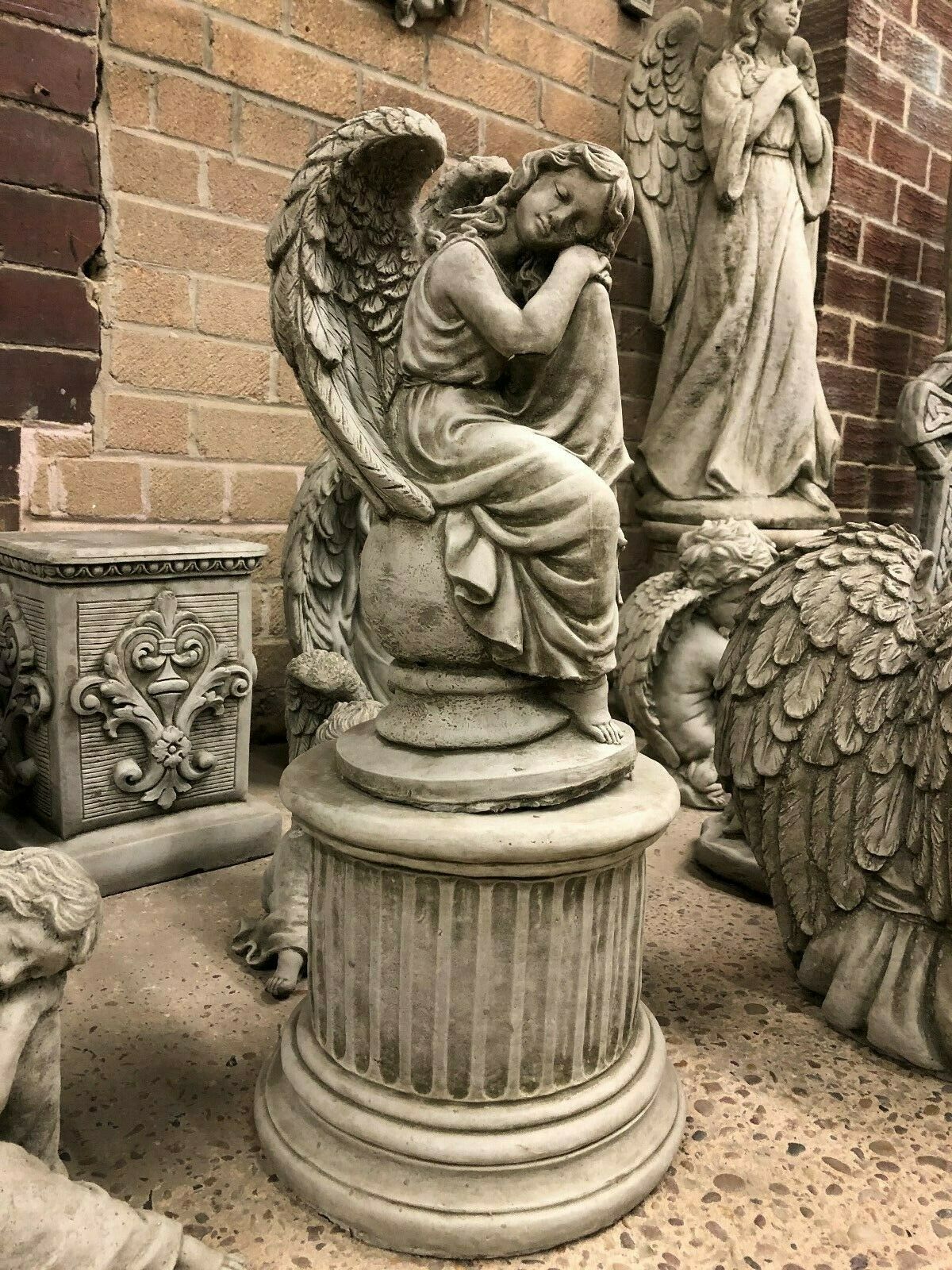 Stone Angel Garden Statue on Ball Plinth in fine limestone, featuring a serene angel with folded wings resting on a fluted pedestal base.