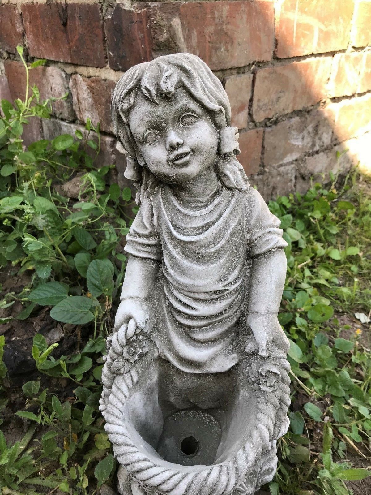 Detailed view of the girl's face and basket on the Stone Basket Girl Garden Planter Ornament, showcasing intricate stone craftsmanship.