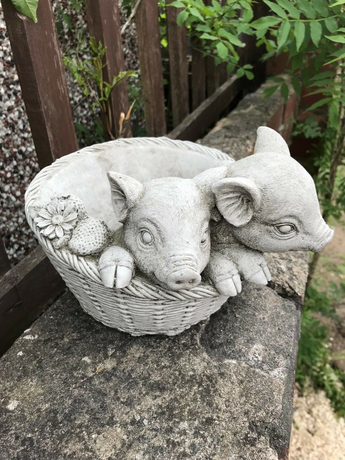 Handcrafted stone pig planter ornament with piglets in a basket and floral detailing. Unique outdoor decor for gardens and patios.
