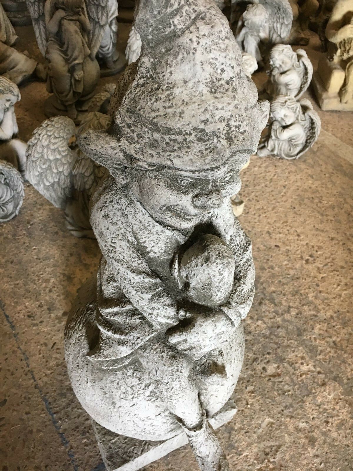 Stone Pixie on Ball Statue - Weatherproof Decor | Durable close-up of pixie hugging knees on stone ball, highlighting facial features and texture.