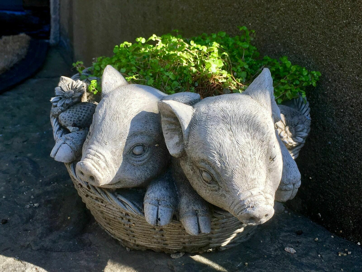 Stone pig planter ornament with greenery, featuring piglets in a basket with flower and strawberry accents. Weather-resistant garden sculpture.