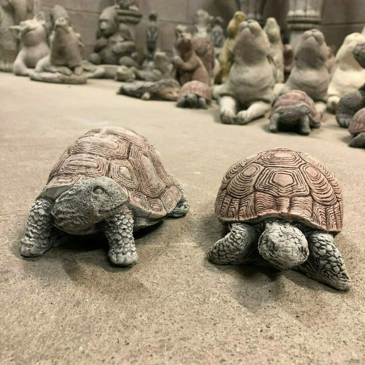 Pair of durable stone tortoise garden ornaments with antique finish, ideal for outdoor lawn decor and weather-resistant garden sculpture display.
