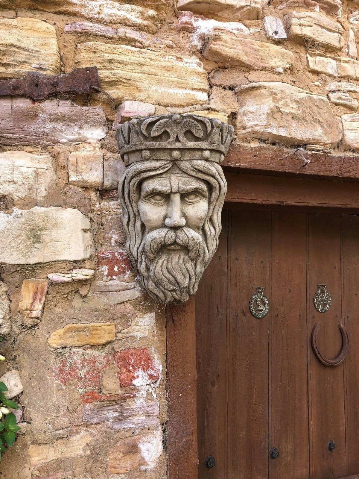 Ornate King Garden Planter with antique finish above wooden door, adding majestic charm to garden or porch entryway.