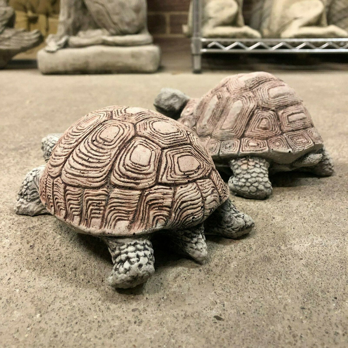 Antique-style stone tortoise ornaments shown from rear angle, highlighting intricate shell patterns and durable craftsmanship for garden decoration.