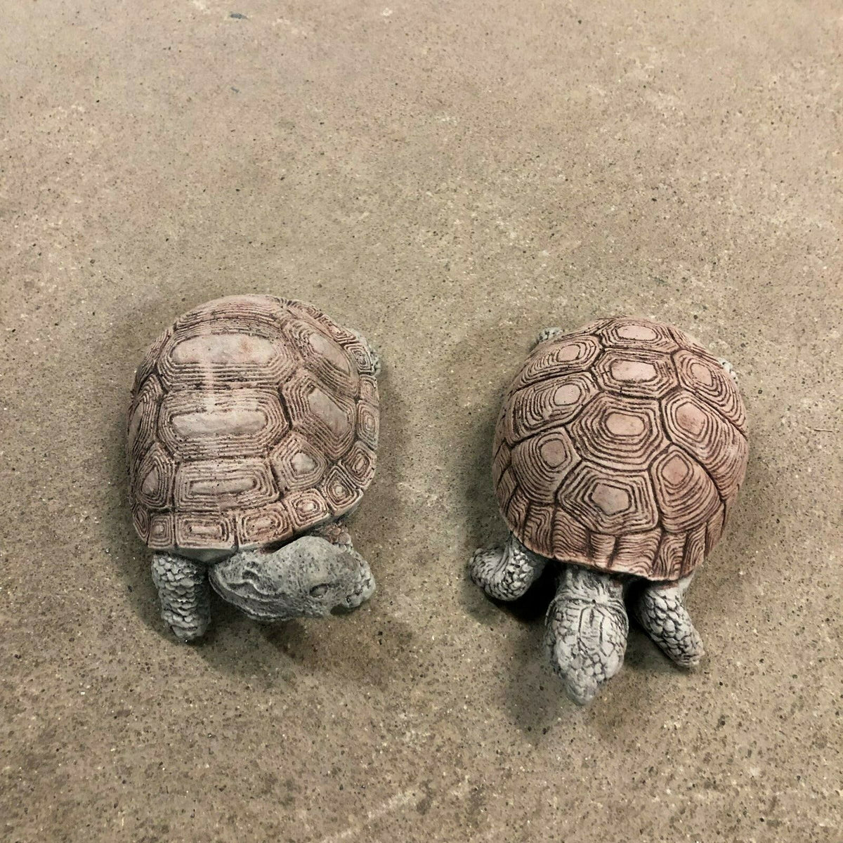 Pair of small stone tortoise ornaments with weathered texture, designed for garden beds, patios, or lawn sculpture arrangements.