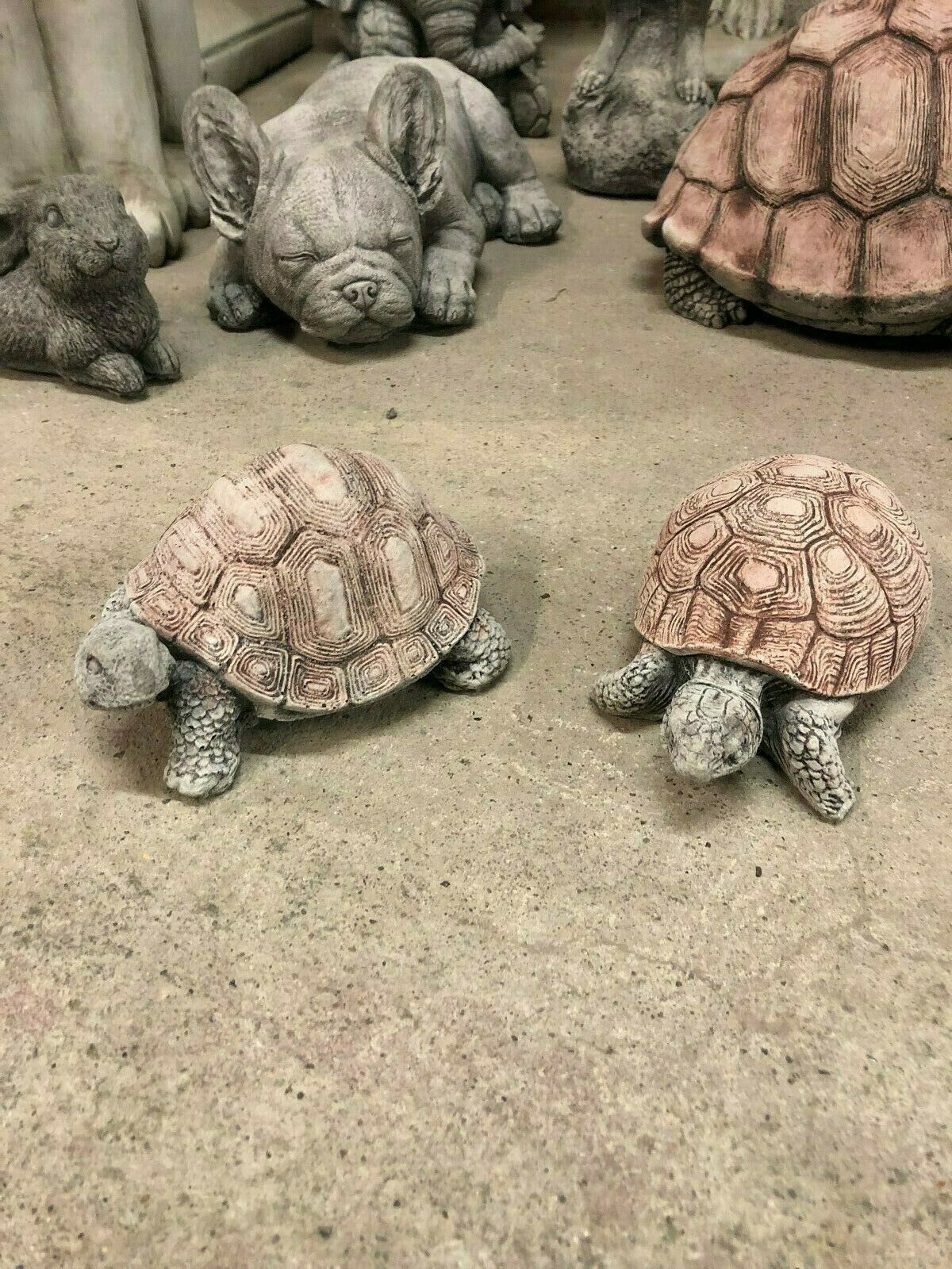 Two stone tortoise ornaments placed among other garden animal sculptures, ideal for creating a whimsical and durable outdoor decor theme.