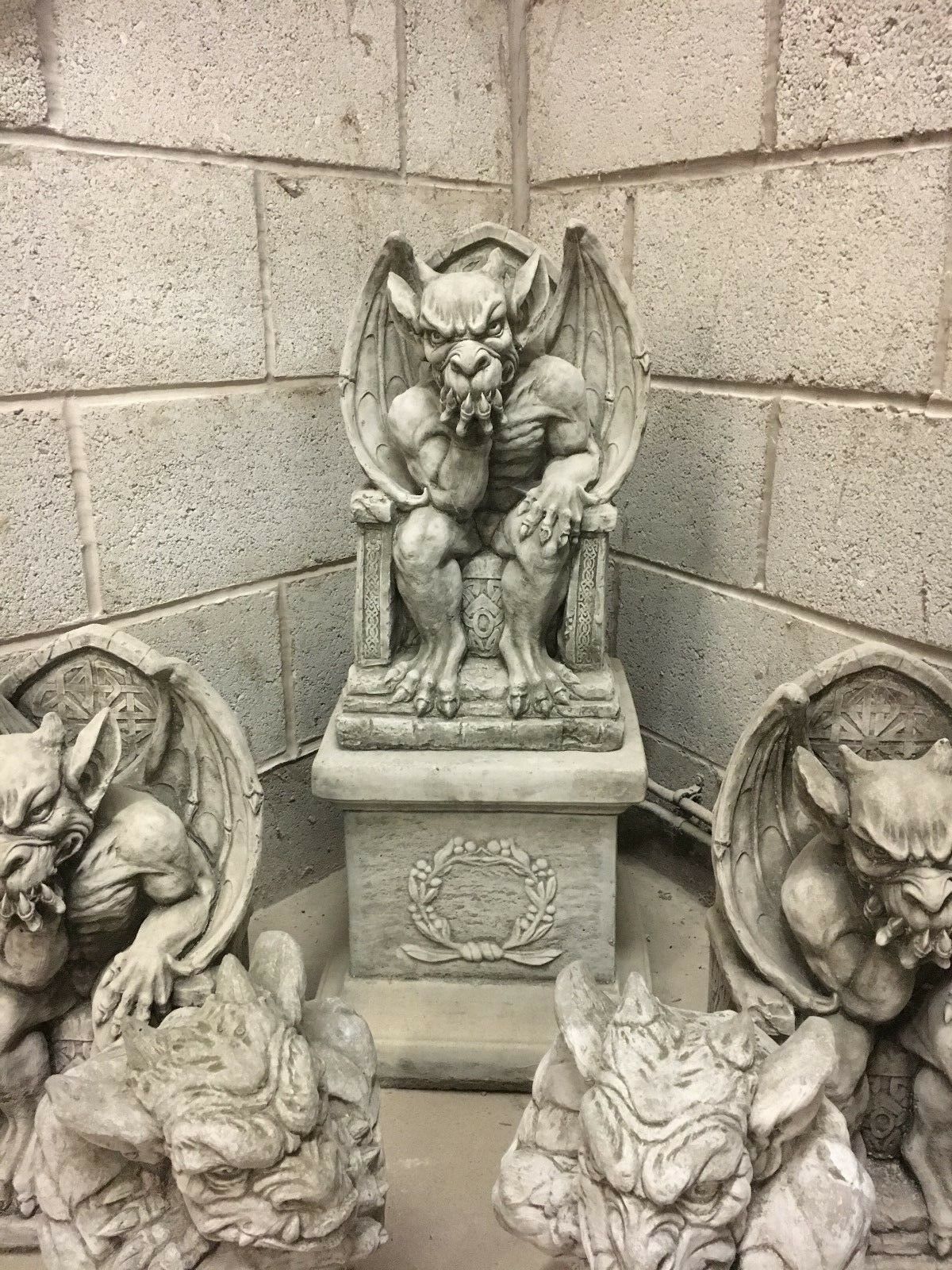 King Gargoyle Stone Statue - Weather Resistant Garden Art displayed with other gargoyle statues in a stone-walled room, showcasing collection potential.