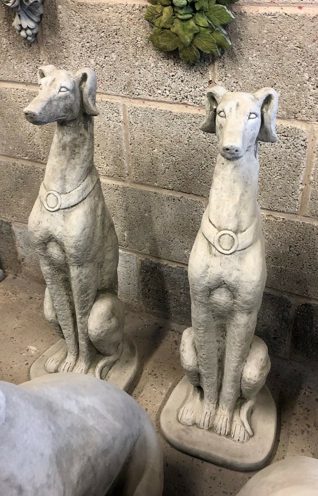 Two matching Saluki dog statues made from durable stone, ideal for flanking garden paths or patios. Classic design for outdoor decor.