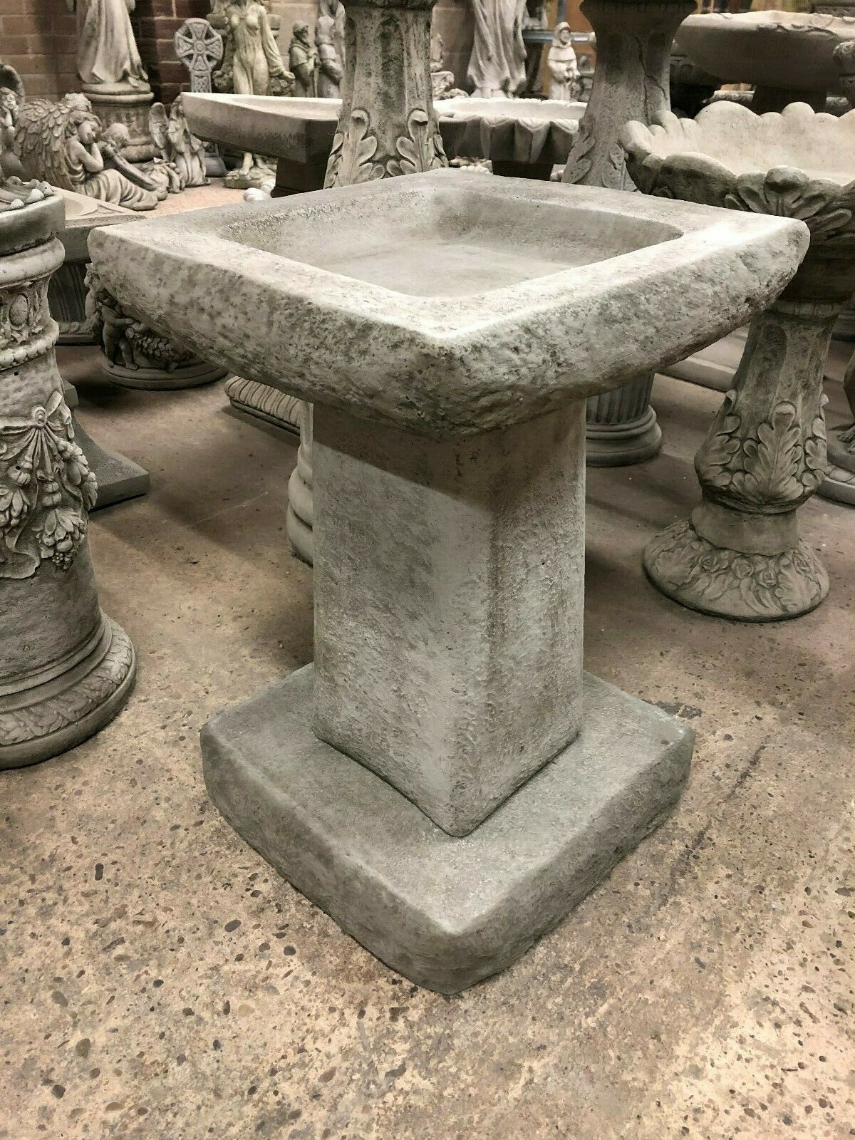 Stone bird bath with chunky square design and antique grey finish, ideal for garden decor. Heavy limestone base ensures stability outdoors.