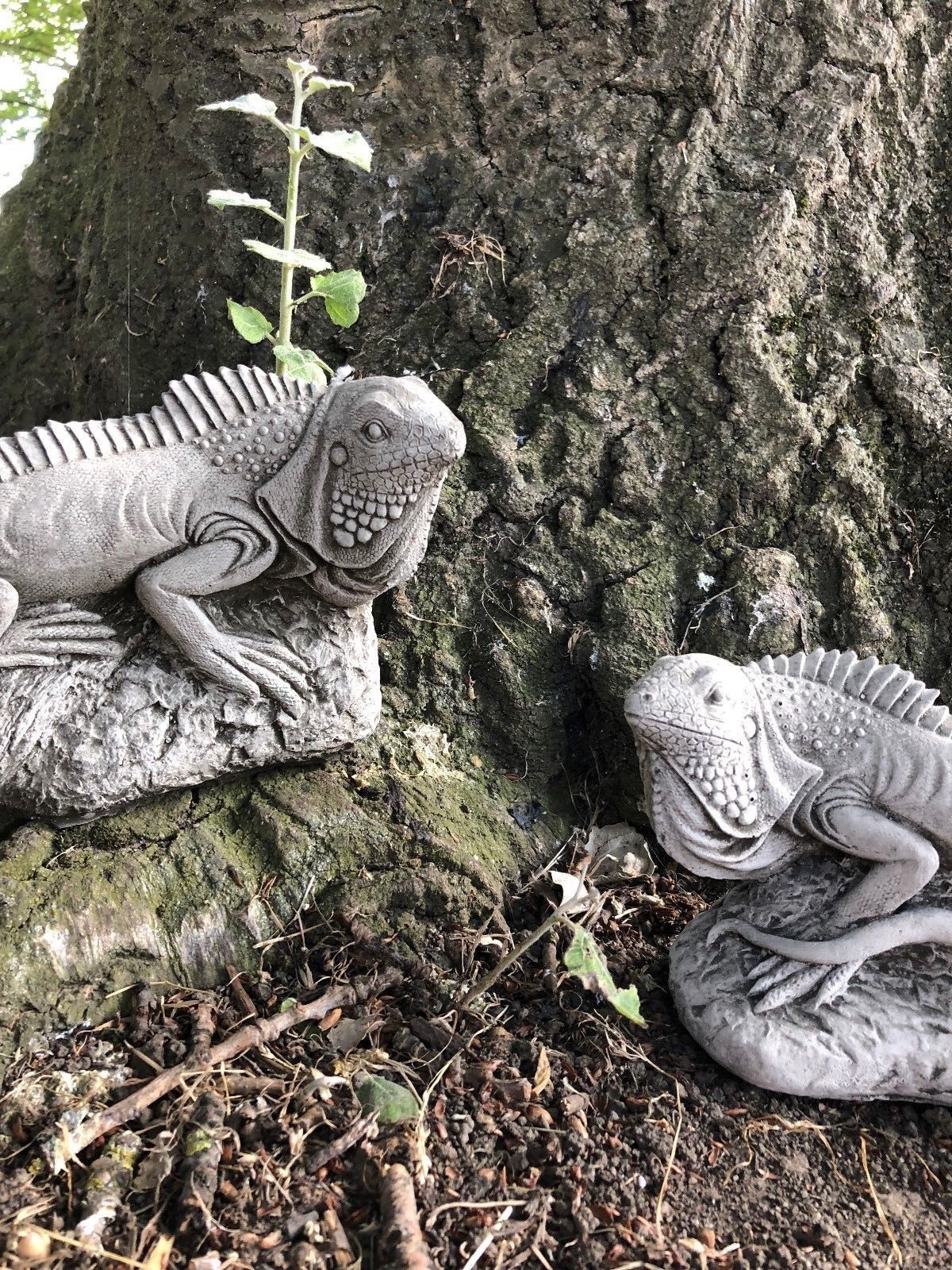 Detailed limestone iguana sculptures from the Stone Garden Ornaments Collection nestled at a tree base, ideal for enhancing natural garden landscapes.