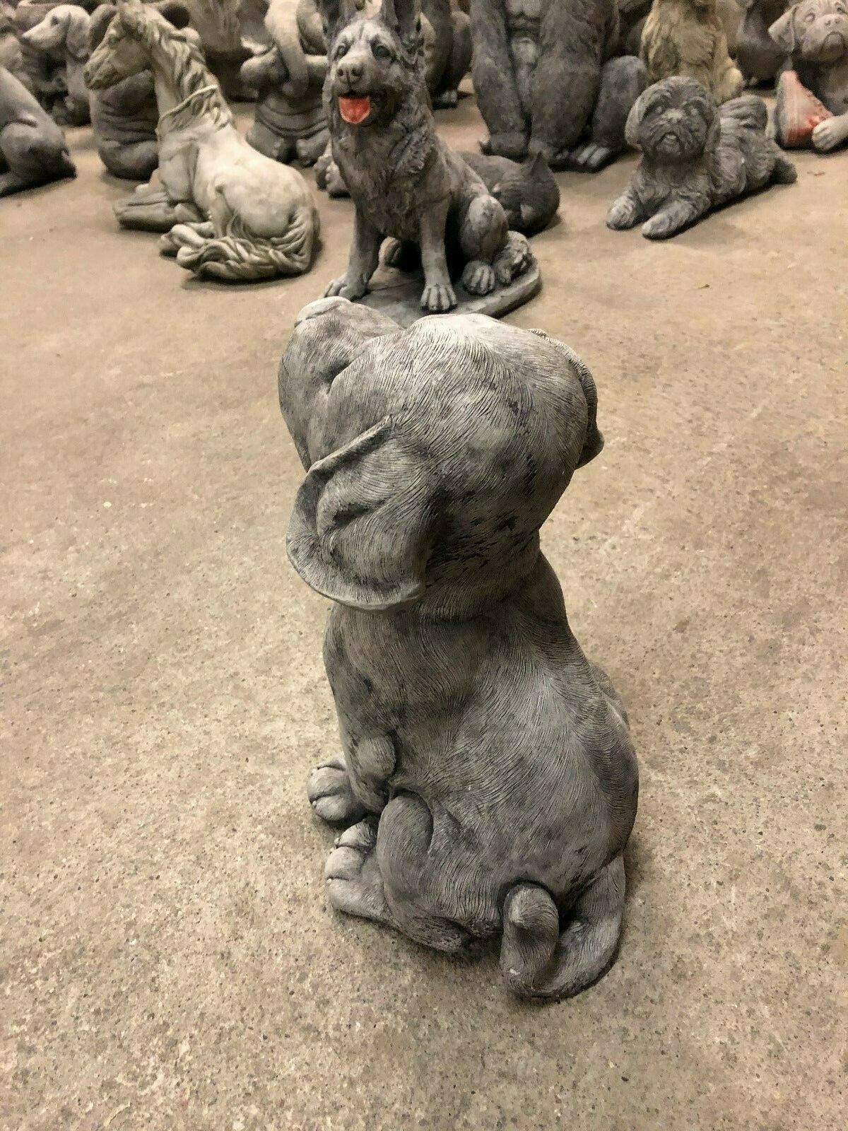 Rear side view of stone puppy garden ornament with curled tail and textured finish. Durable design for garden or patio decoration.