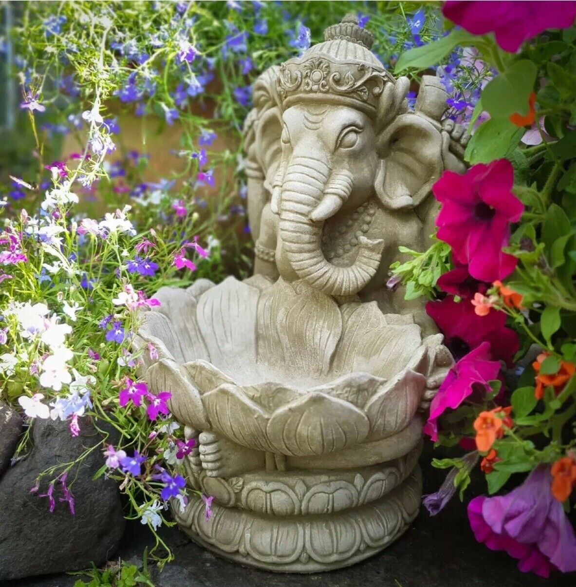 Ganesh Garden Statue - Stone Lotus Flower surrounded by vibrant flowers, ideal as a weatherproof bird bath or tealight holder for outdoor decor.