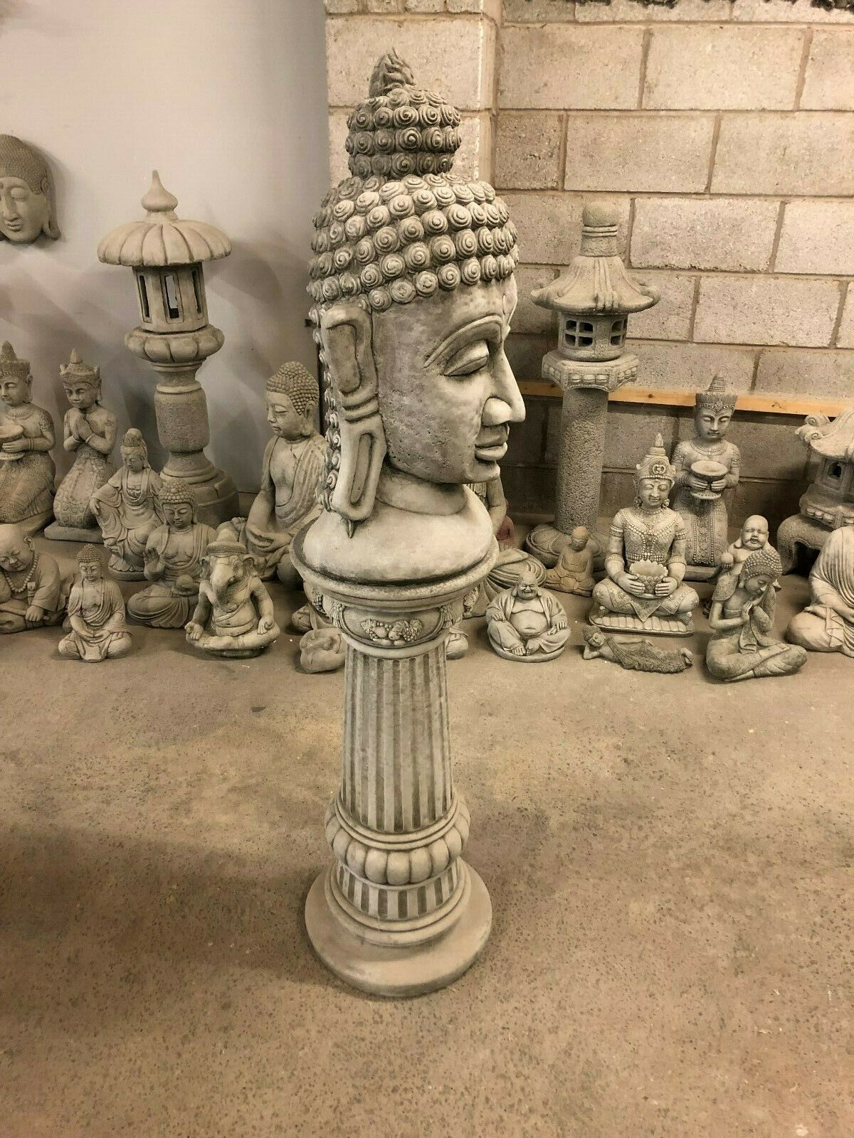 Side profile of Stone Buddha Head Garden Statue on classical column. Ideal for tranquil outdoor spaces or decorative garden corners.