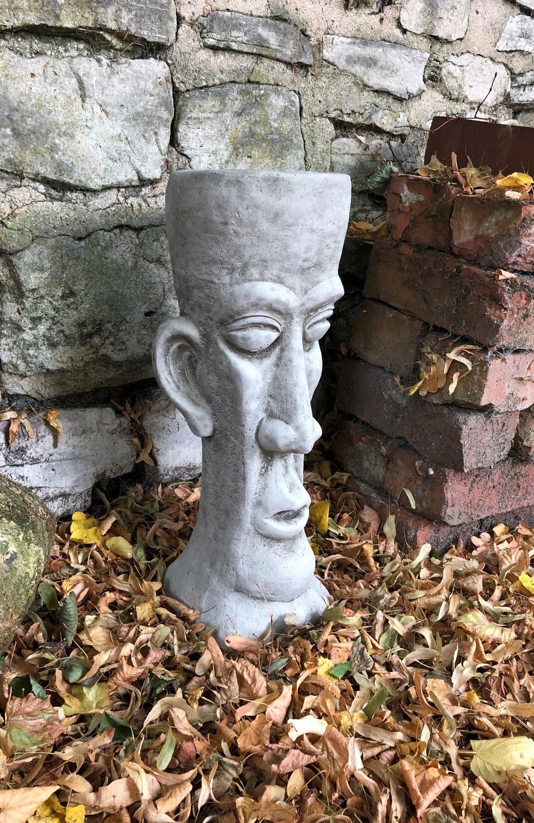 Side view of the Stone Easter Island Head Planter showing detailed facial features and textured limestone surface, perfect for patios or lawns.